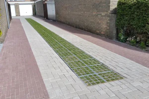 Strook grastegels in een klinkerstraatje, waterdoorlatende bestrating in Amsterdam